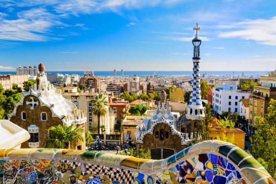 Blick &uuml;ber Barcelona mit seiner bunten Architektur, am Horizont das Meer